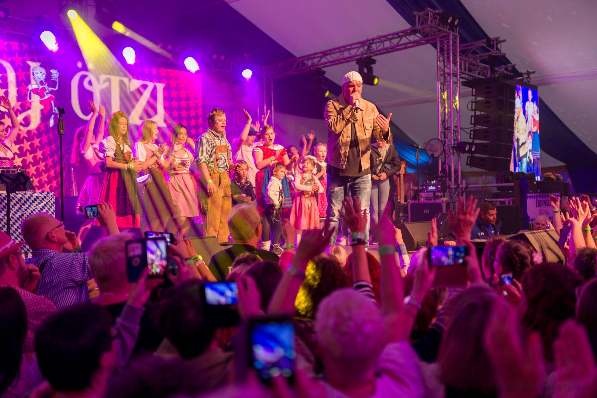 Mann steht auf einer Bühne und singt vor einem großen Publikum