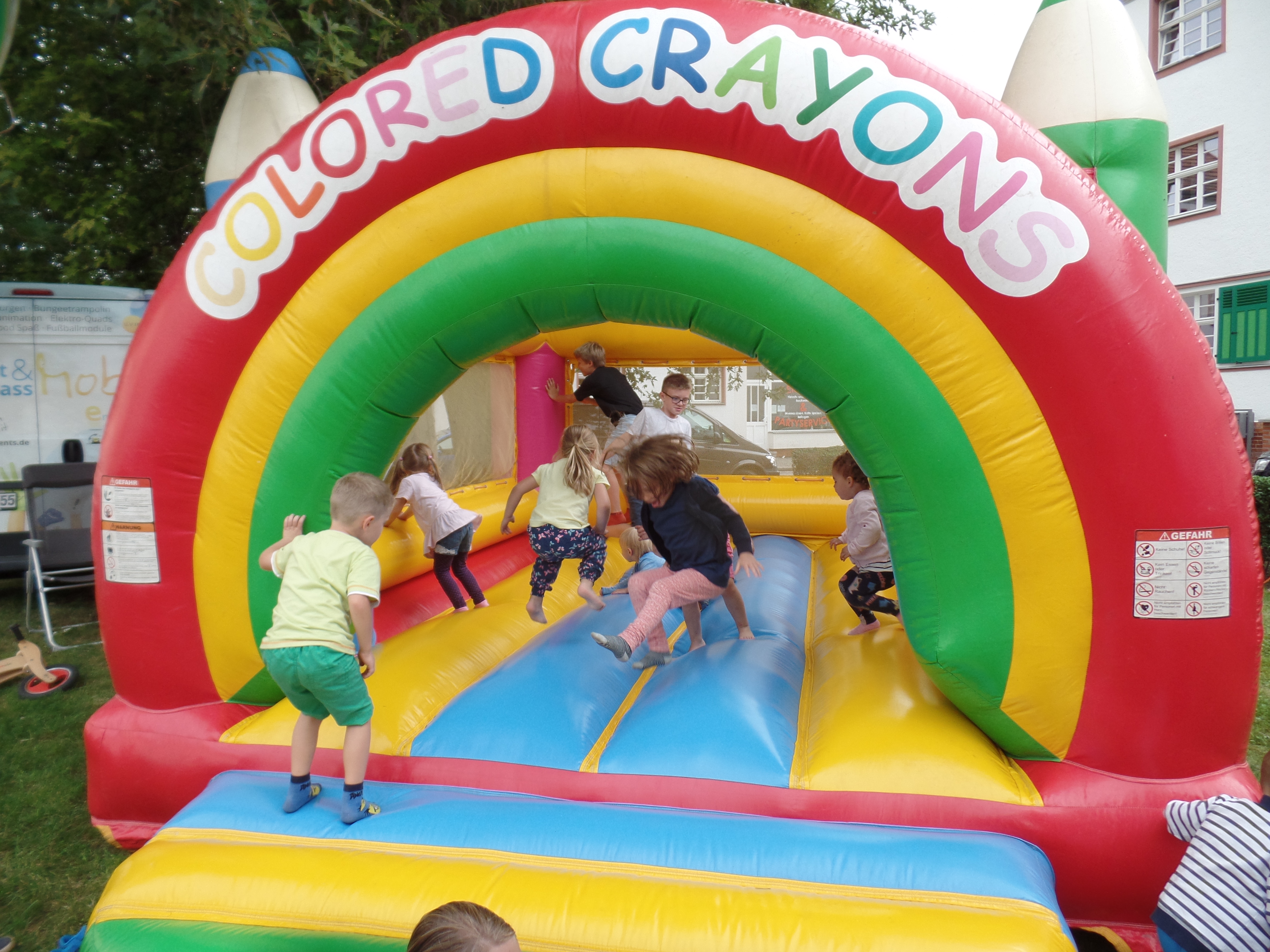 Kinder springen auf einer bunten Hupfburg