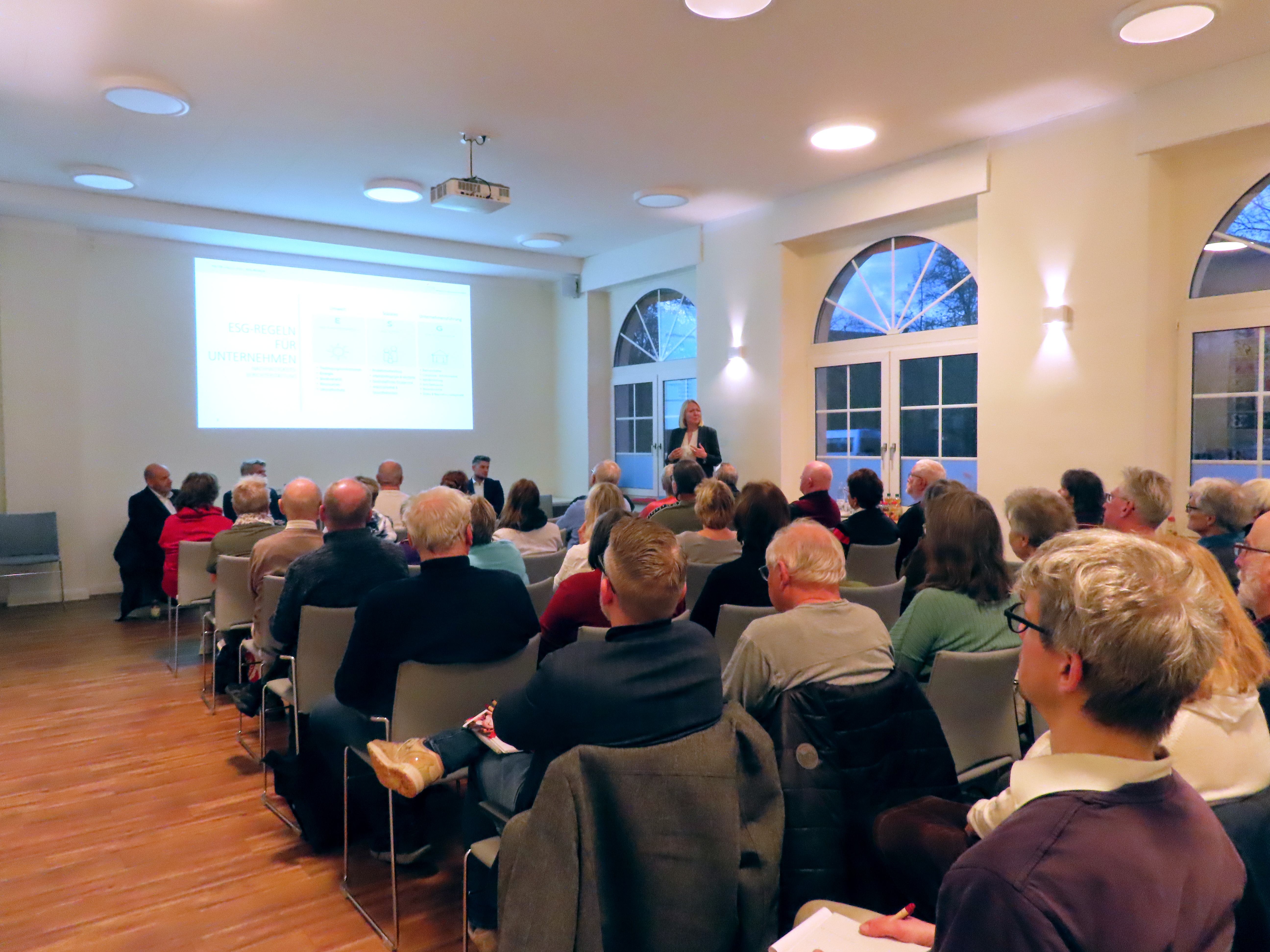 Frau Wartmann präsentiert wichtige Informationen zur 1893 an der Leinwand im 1893-Treff und interessierte Mieter sind als Gäste anwesend
